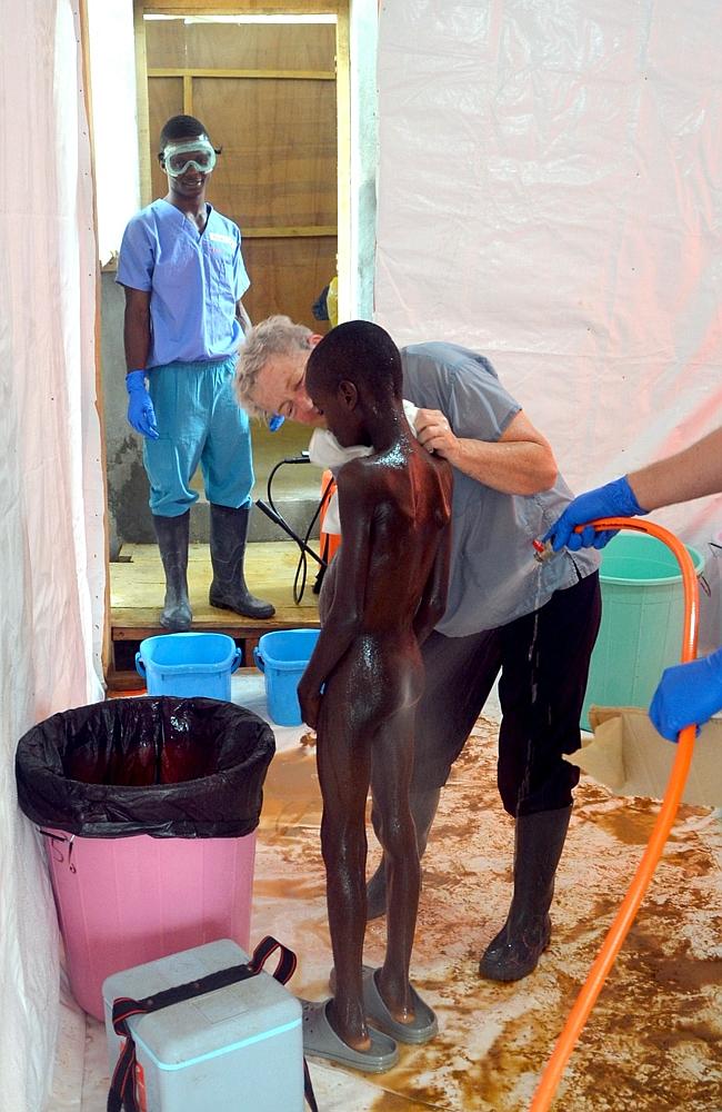 A 10-year-old Liberian boy is showered after being taken out of ebola quarantine followin