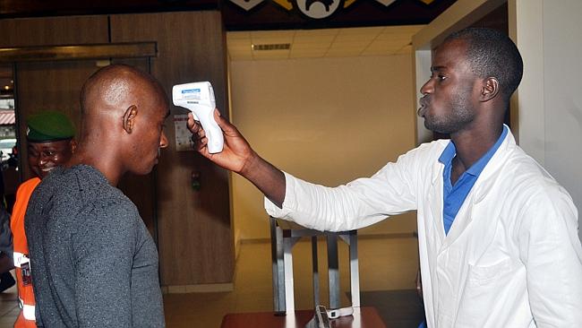 A health agent checks a passenger leaving Guinea / Picture: AFP