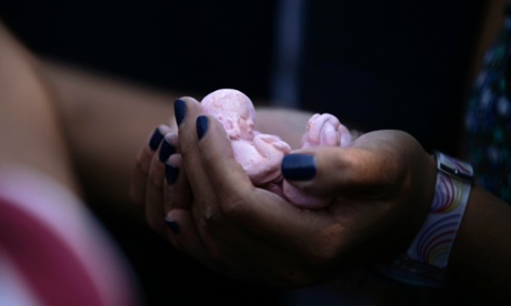 An anti-abortion activist holds clay dolls in the shape of fetuses.