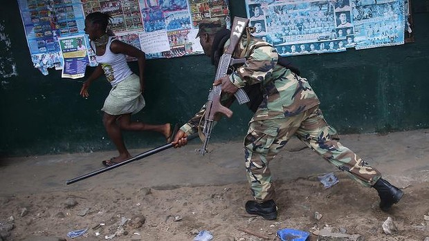 A soldier chases a resident of a slum of 75,000 people who woke up to find themselves under quarantine.