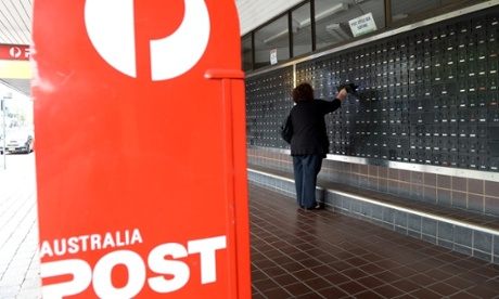 A woman collects mail from an Australia Post private post office box in Sydney