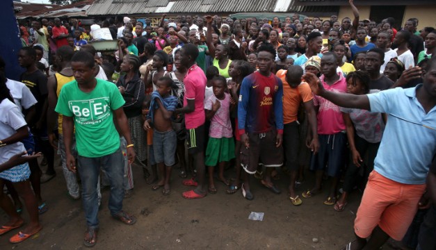  A crowd enters the grounds of an Ebola isolation center in the West Point slum in Monrovia, Liberia, before a group of armed men attacked the facility (Photo by John Moore/Getty Images)