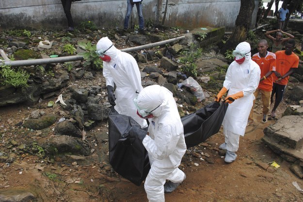 Health workers remove the body of a man whom local residents said died of Ebola in Monrovia, Liberia, in September (Reuters). 