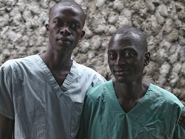 Survivors Mark Jerry, 30, (R), and Zaizay Mulbah, 34, stand together before their shifts 