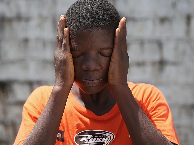 Jeremra Cooper, 16, wipes his face from the heat inside the Médecins Sans Frontières (MSF