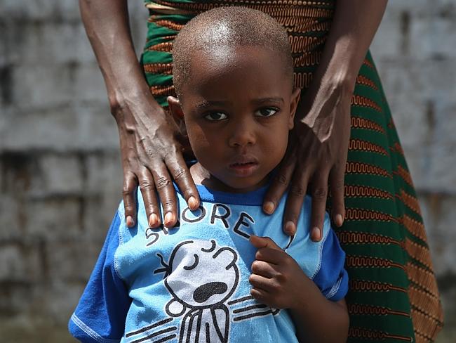 James Mulbah, 2, stands with his mother, Tamah Mulbah, 28, who also recovered from Ebola.