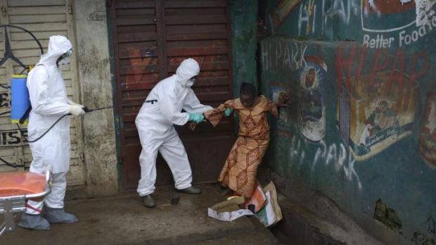 A woman suspected of being infected with Ebola is assisted by health workers to an ambulance for treatment in Freetown, ...