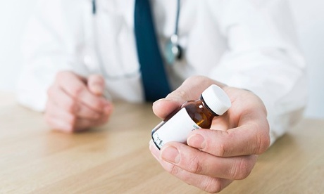 Doctor sitting at desk wearing stethoscope 