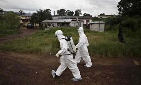 Healthcare workers spray disinfectant to prevent the spread of the Ebola virus in Sierra Leone