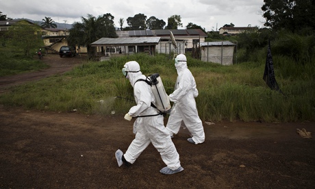 Healthcare workers spray disinfectant to prevent the spread of the Ebola virus in Kenema