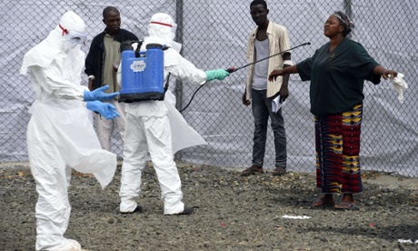 Medical personnel at the Ebola Treatment Centre at Island Hospital in Monrovia disinfect people who have brought in patients suspected of having the Ebola virus.