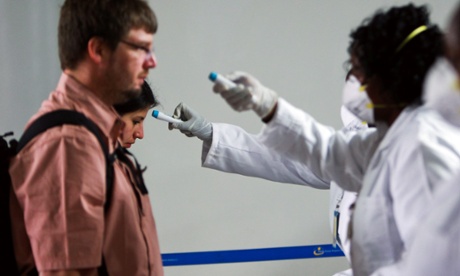 Kenyan health workers from port health service screen for temperatures on travellers coming in from abroad at a screening point to screen them for the Ebola virus.