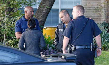 Police confer as a barrel for disposal of hazardous waste sits outside the apartment of the health worker.