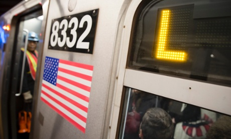 Riders stand inside an L-Train subway car on Thursday in New York.