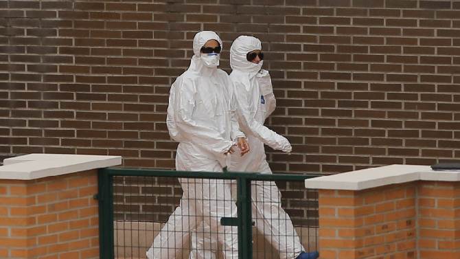 Health care workers in protective gear are seen outside of Carlos III hospital in Madrid, where nurse Teresa Romero is being treated for Ebola.