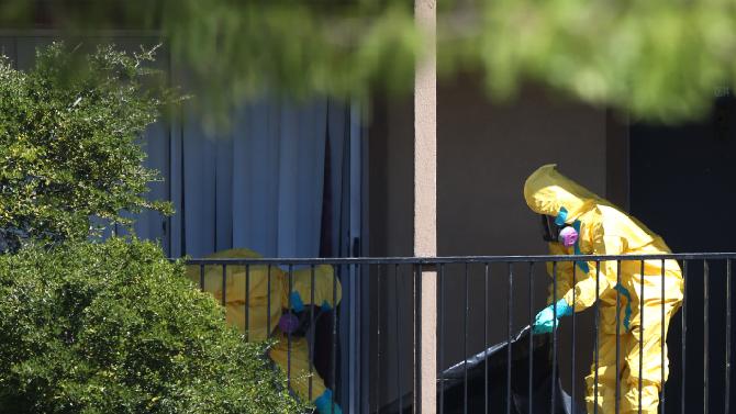 Hazmat crews are seen cleaning the nurse's Dallas-area apartment.