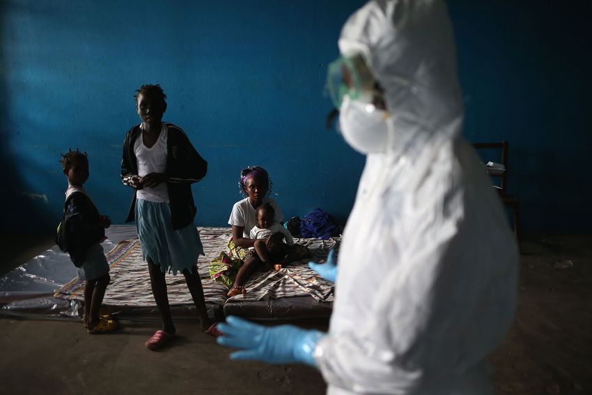 A Liberian health worker speaks with families in a classroom now used as Ebola isolation ward on August 15, 2014 in Monrovia, Liberia.