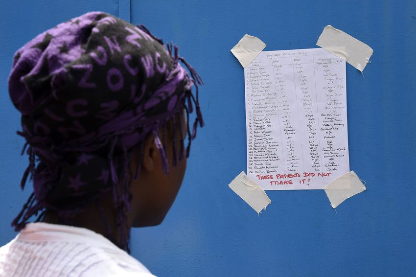 A woman reads the list of people who died of the Ebola virus at Island Hospital in Monrovia on Sept. 30, 2014.