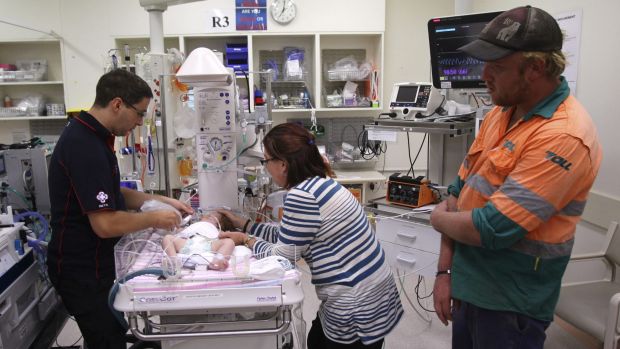 Jacqui Sansom and Jason Moran watch NETS doctor Ben Lakin tend to their daughter, Allira.