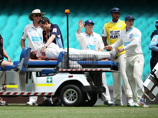 NSW players and medical staff assist Phillip Hughes after he fell to the ground.