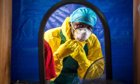 A healthcare worker dressing in protective gear before entering an Ebola treatment center in the west of Freetown, Sierra Leone.