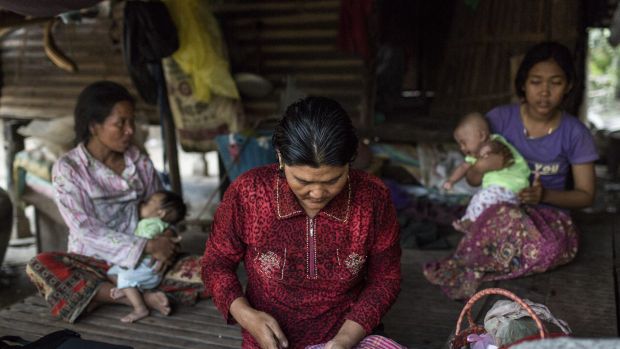 Em Mom prepares anti-retroviral medication for her mother, Chhay Yao, in Roka, Cambodia.