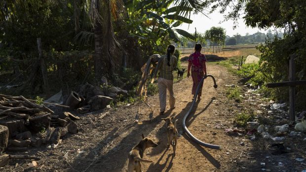 Em Seiha, who learned she was infected with HIV, and Em Mom go to work in the rice fields in Roka, Cambodia.