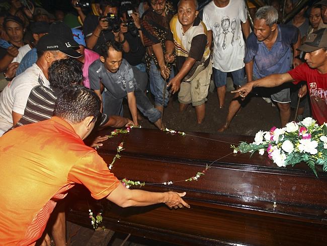 Funerals begin ... Relatives lower the coffin containing the body of Hayati Lutfiah Hamid