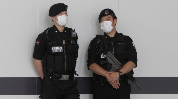 Airport guards wear masks as a precaution against the MERS virus at the Incheon International Airport on on the weekend.