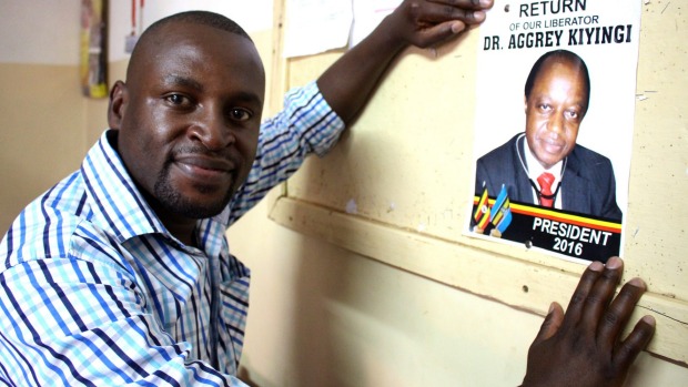 A student puts up campaign material for Ugandan opposition presidential candidate Aggrey Kiyingi in Kampala.