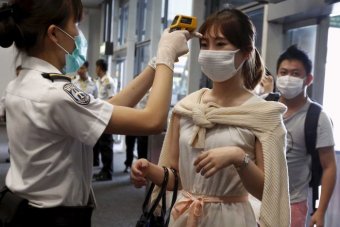 Hong Kong airport staff screen passengers from South Korea