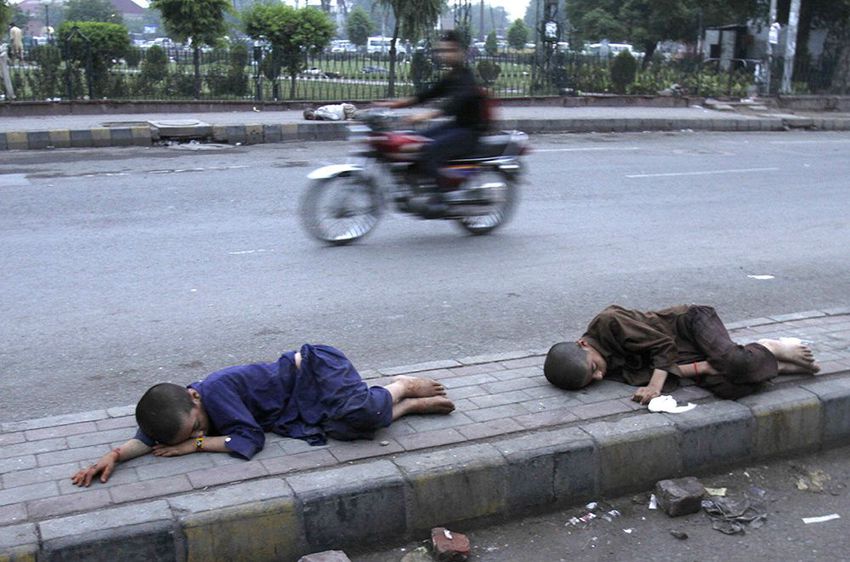 Homeless Pakistani children sleep at a roadside as weather cools down in Lahore, Pakistan on June 24, 2015. Wind from the sea and pre-monsoon rains cooled southern Pakistan on Wednesday, likely marking the end of the scorching heat wave.