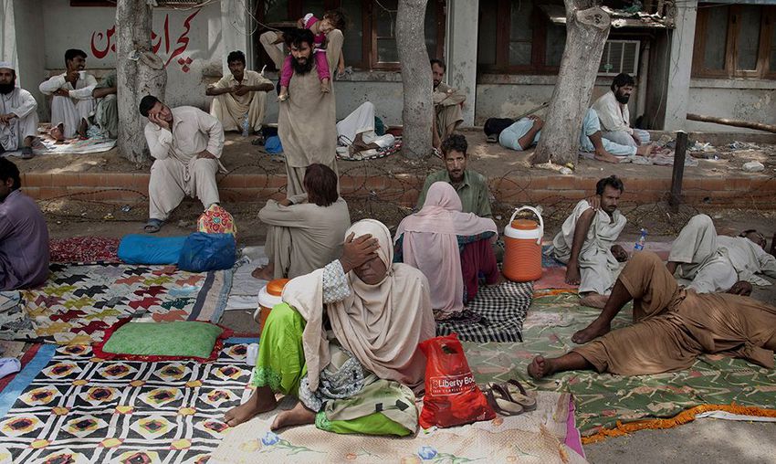 Relatives of patients suffering from heatstrokes take shelter under trees at a local hospital in Karachi, Pakistan on June 24, 2015.