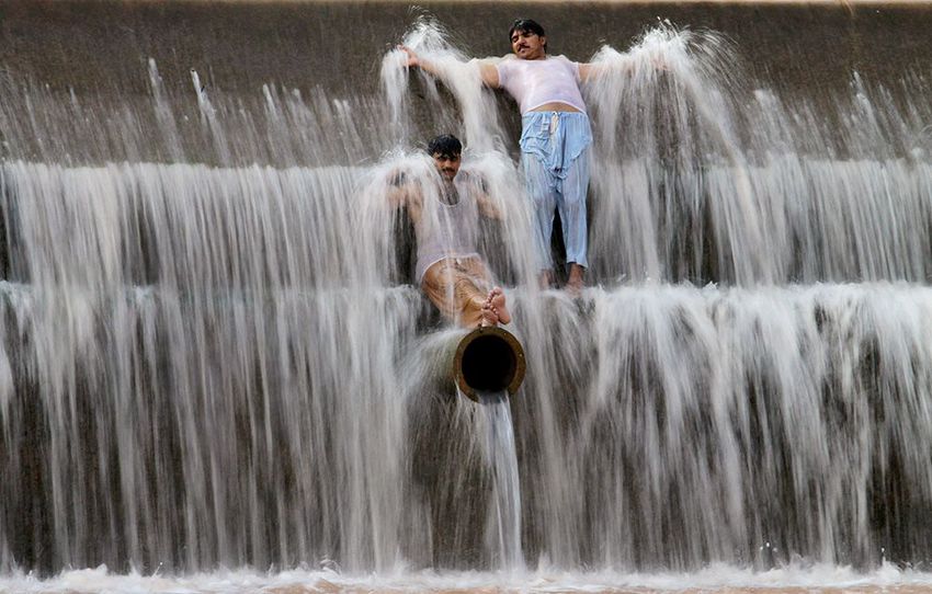 Pakistanis cool off themselves at a river on the outskirts of Islamabad, Pakistan.