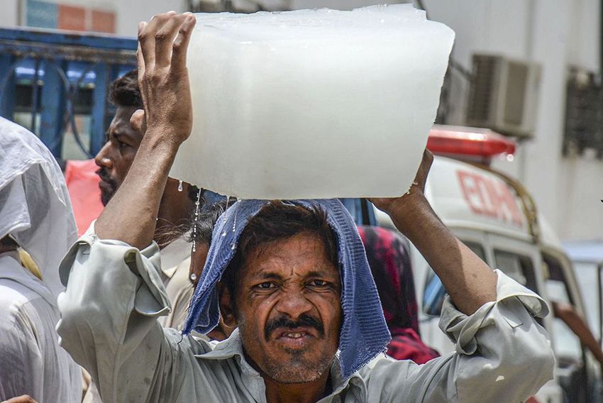 A Pakistani man carries an ice block on his head outside a hospital during a heatwave in Karachi, Pakistan on June 24, 2015. More than 1,000 people have been killed over five days by a searing heatwave in Pakistan, with the worst effects in the country's commercial capital Karachi.