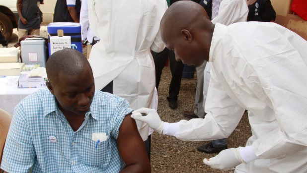 A health worker cleans a man's arm before injecting him with a Ebola vaccine in Conakry, Guinea, in March.