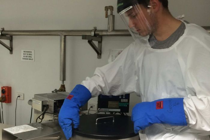 Michael Penrose handles cancer tumours frozen in liquid nitrogen in a cryogenic freezer